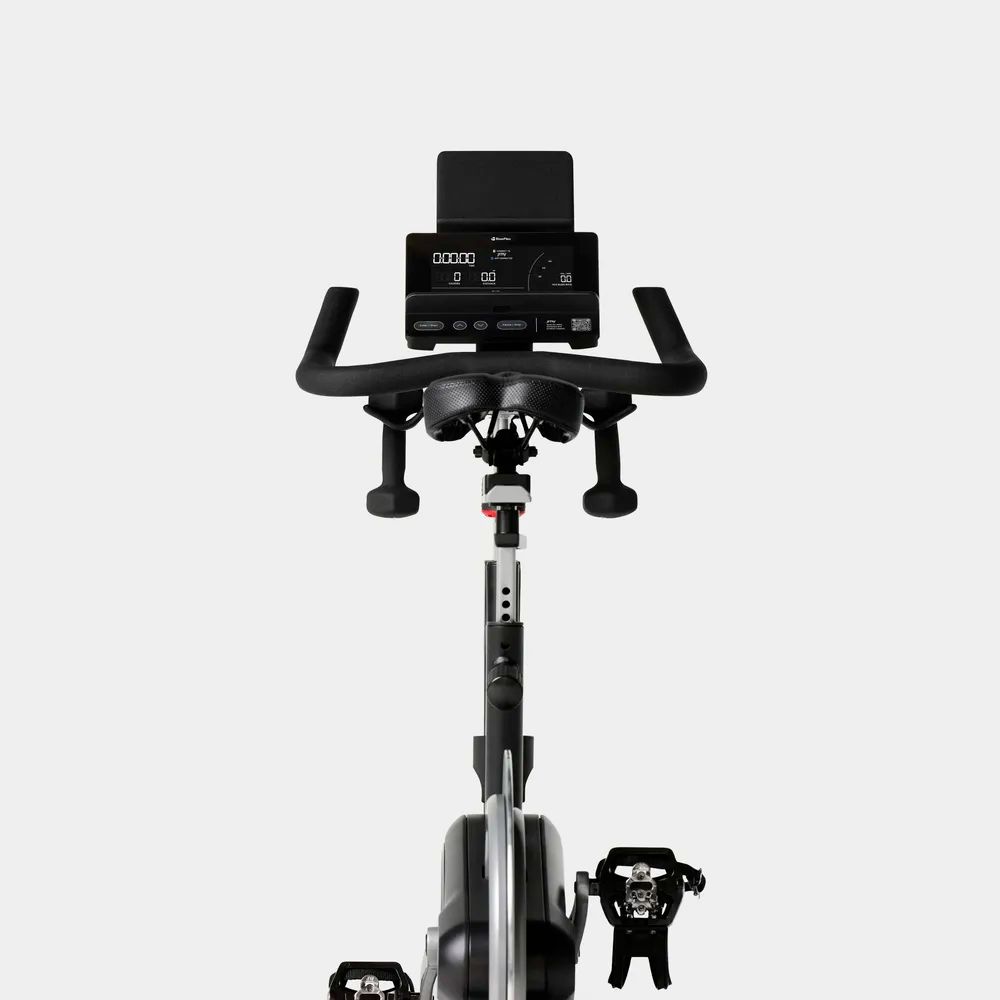 Nahaufnahme des Ergometer-Displays. Es zeigt Informationen an. Der Lenker und die Pedale sind ebenfalls sichtbar.