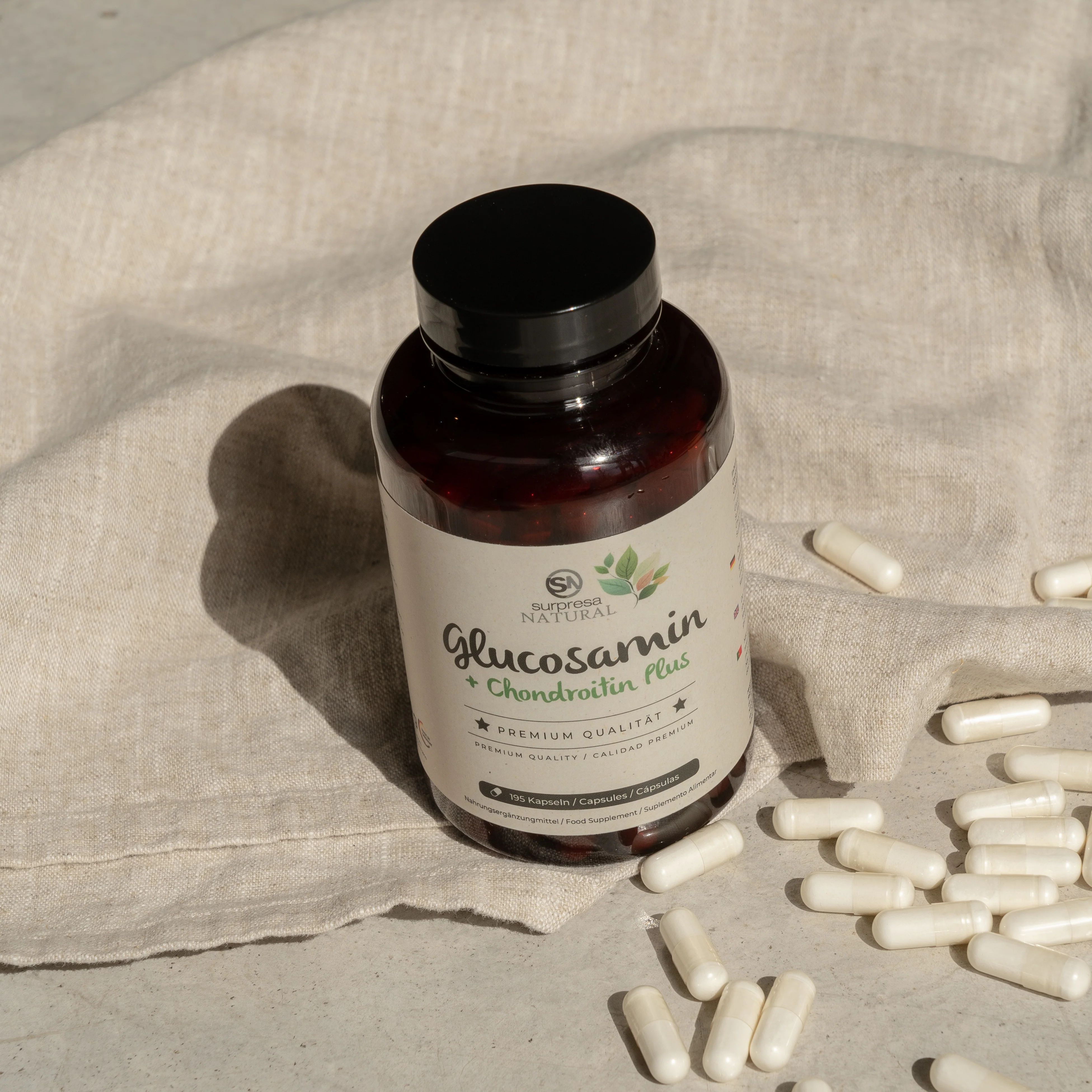 Braune Flasche mit schwarzen Deckel und Kapseln. Aufschrift: Glucosamin + Chondroitin Plus. Premium Qualität. Kapseln liegen daneben.