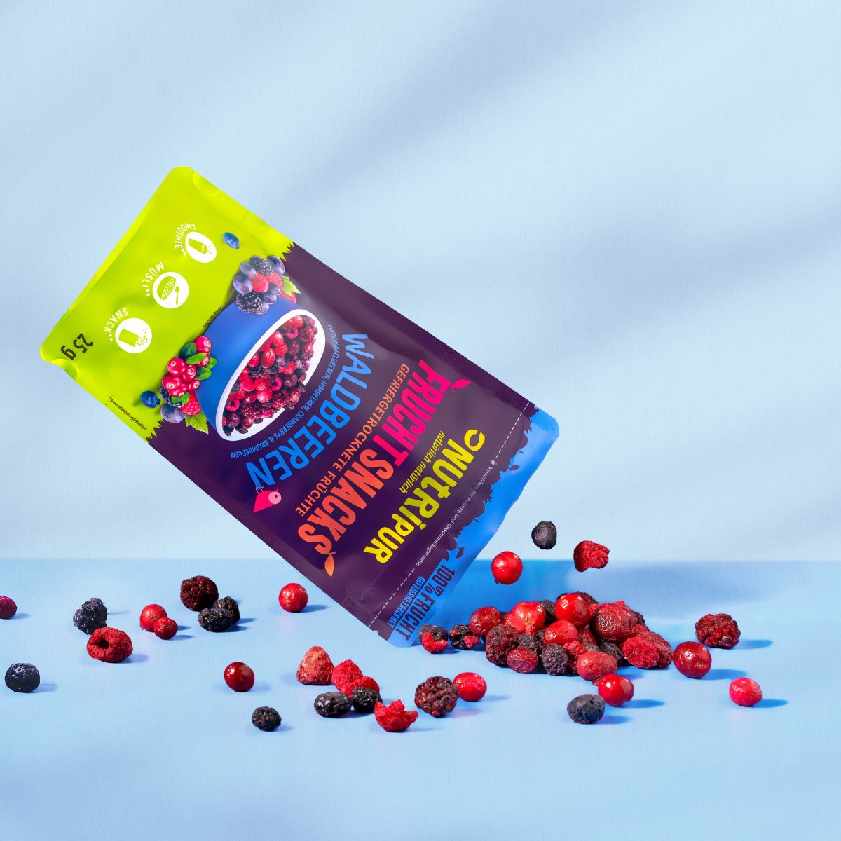 Packung NutriPur Waldbeeren kippt Beeren aus. Aufschrift: Fruchtsnacks, 25g.
