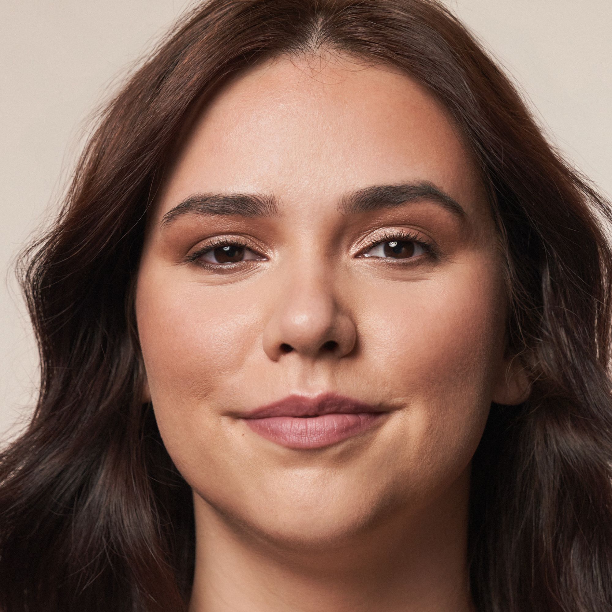 Porträt einer Frau mit Bronzer. Natürliches Make-up. Gebräunter Teint, leichtes Rouge, betonte Augenbrauen.