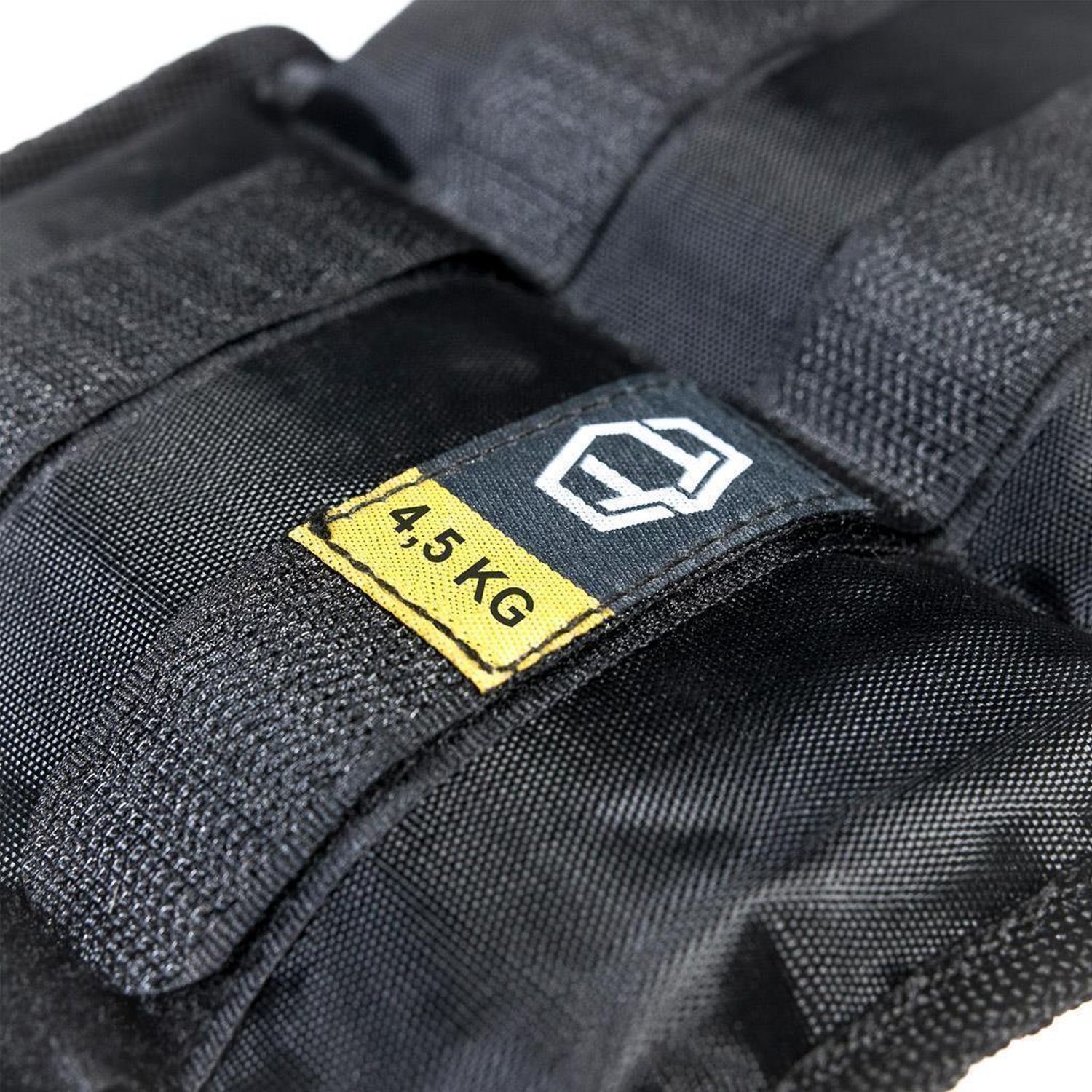 Schwarze Gewichtsmanschette mit gelbem Etikett. Aufschrift "4,5 KG". Logo mit weißem Rahmen. Schwarzes Textilmaterial.