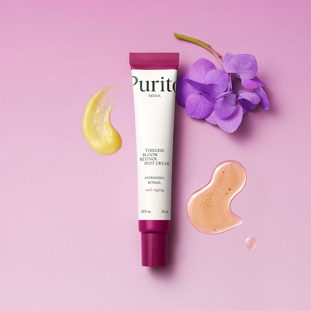PURITO Timeless Bloom Retinol Spot Cream Tube mit Cremeproben und Blüte.