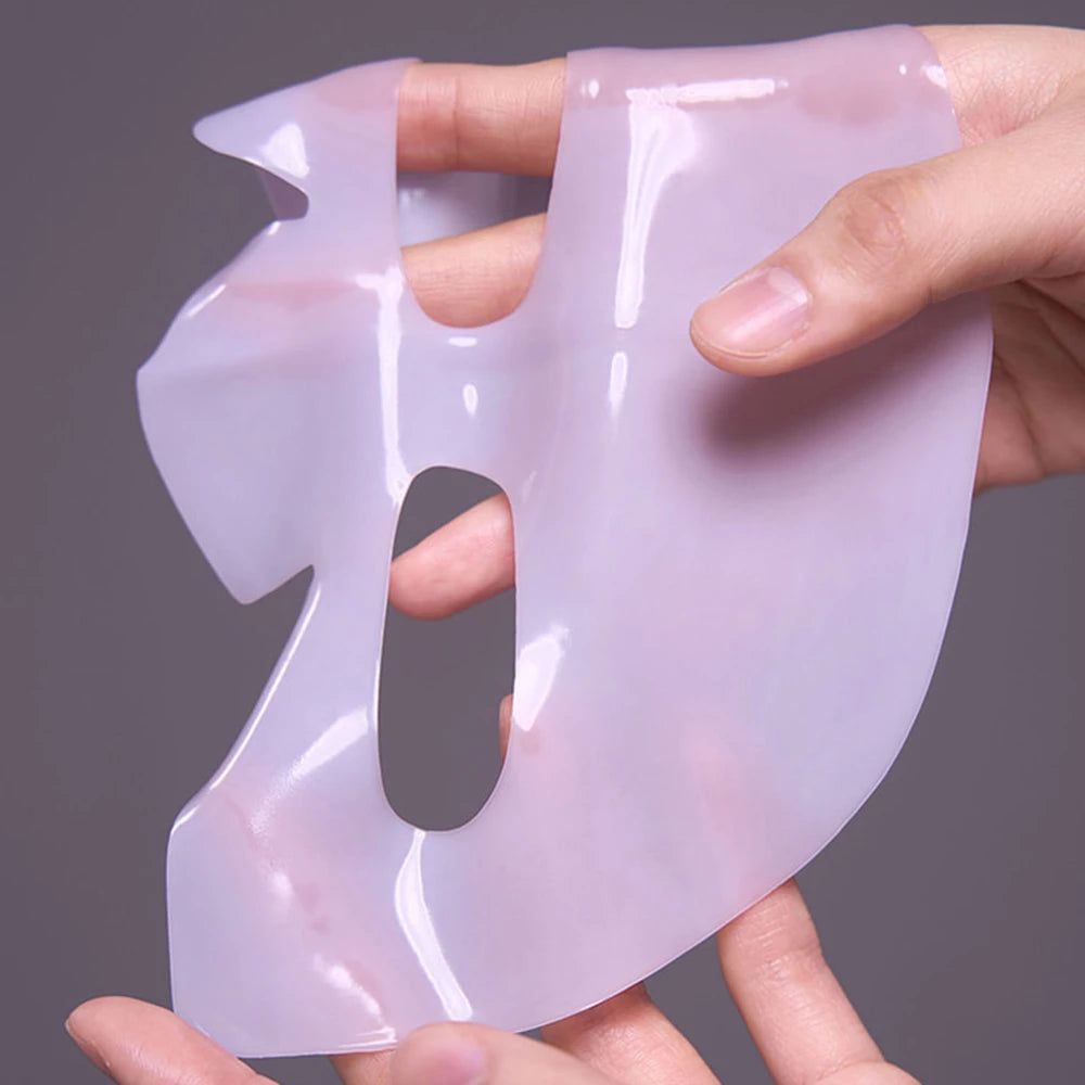 Gesichtsmaske aus durchscheinendem Material, gehalten von Händen. Aussparungen für Augen, Nase und Mund.