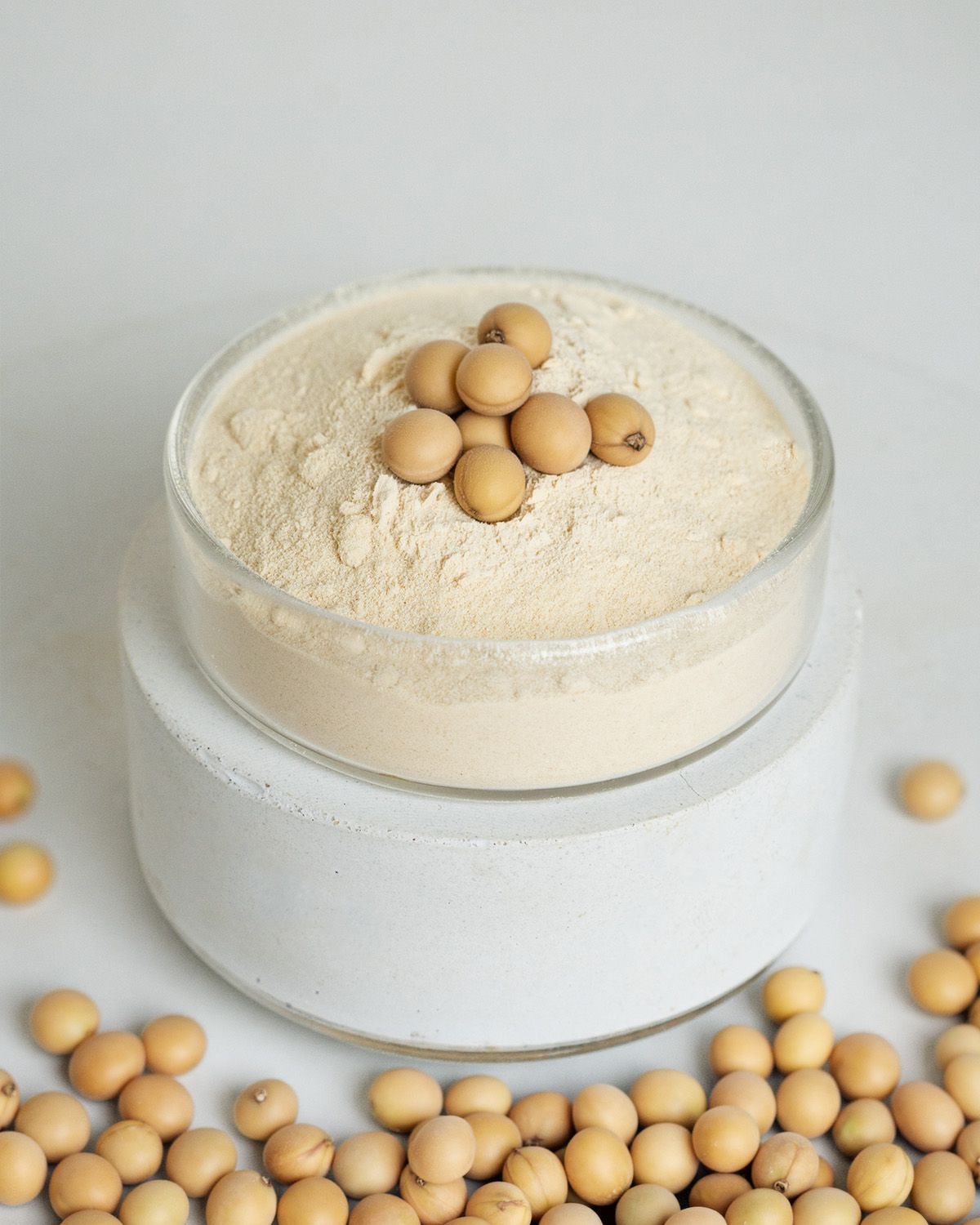 Soja Lecithin Pulver in einer Glasschale, garniert mit Sojabohnen.