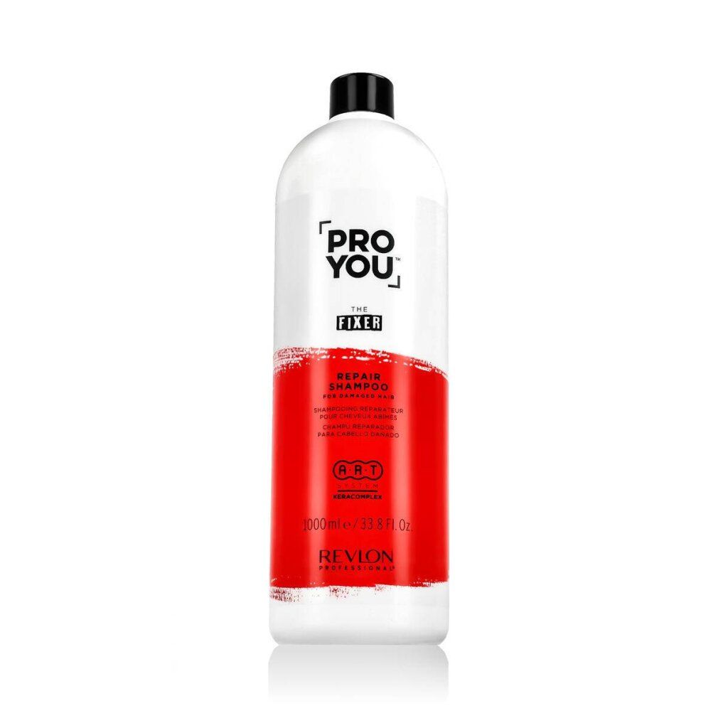 Weiße Flasche mit schwarzem Deckel. Aufschrift: Pro You The Fixer Repair Shampoo. Roter Bereich. Revlon Professional.