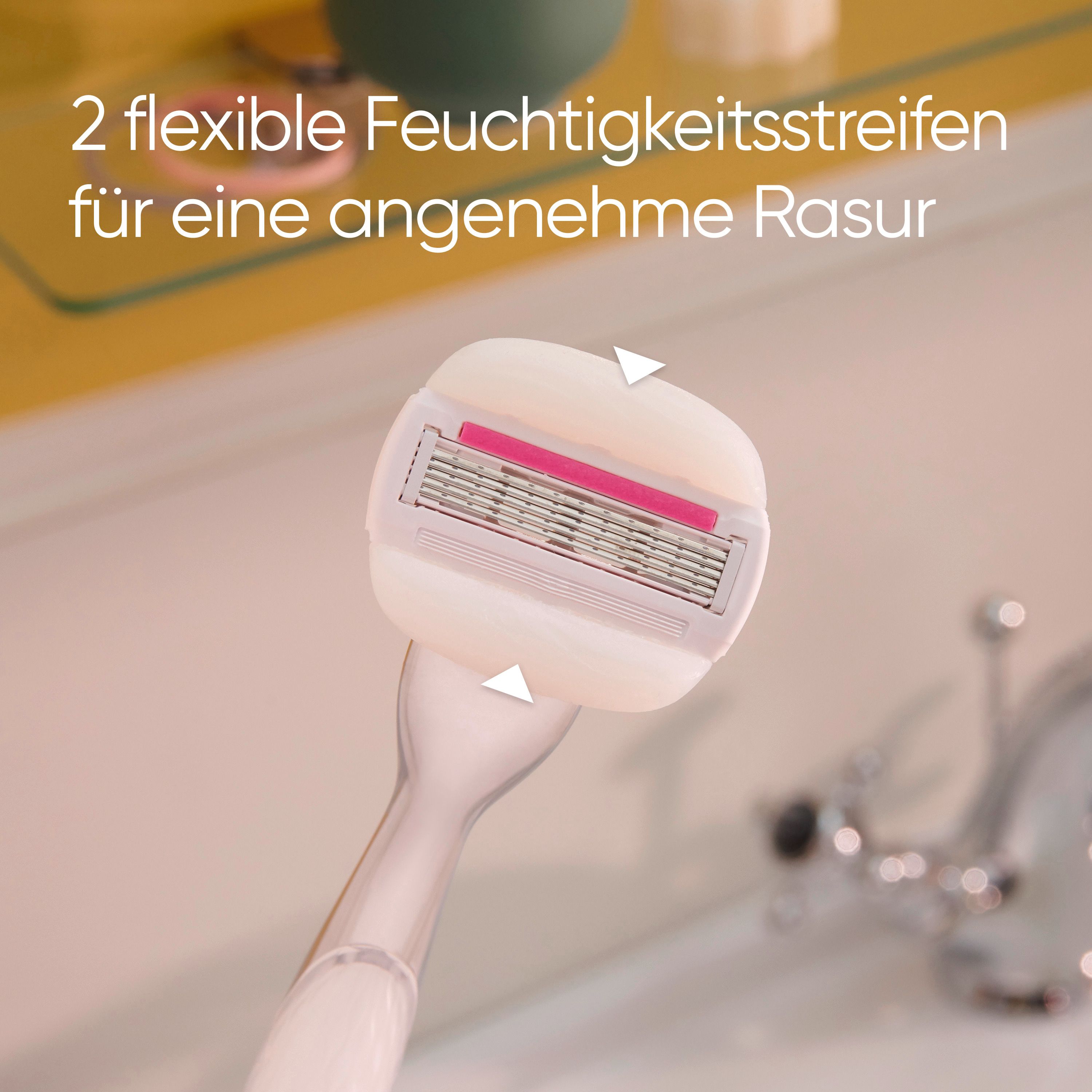 Nahaufnahme des Rasiererkopfes. Weißer Rasiererkopf mit rosa Streifen. Text: 2 flexible Feuchtigkeitsstreifen.