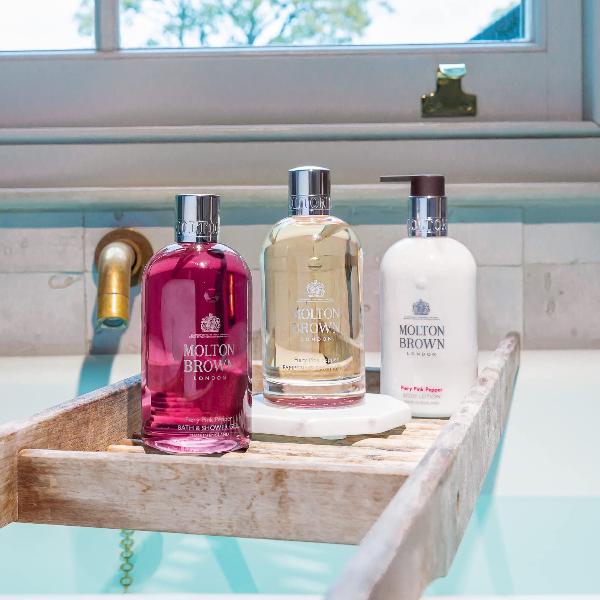 Weiße Bodylotion-Flasche mit Pumpspender, silbernem Halsband und Etikett.