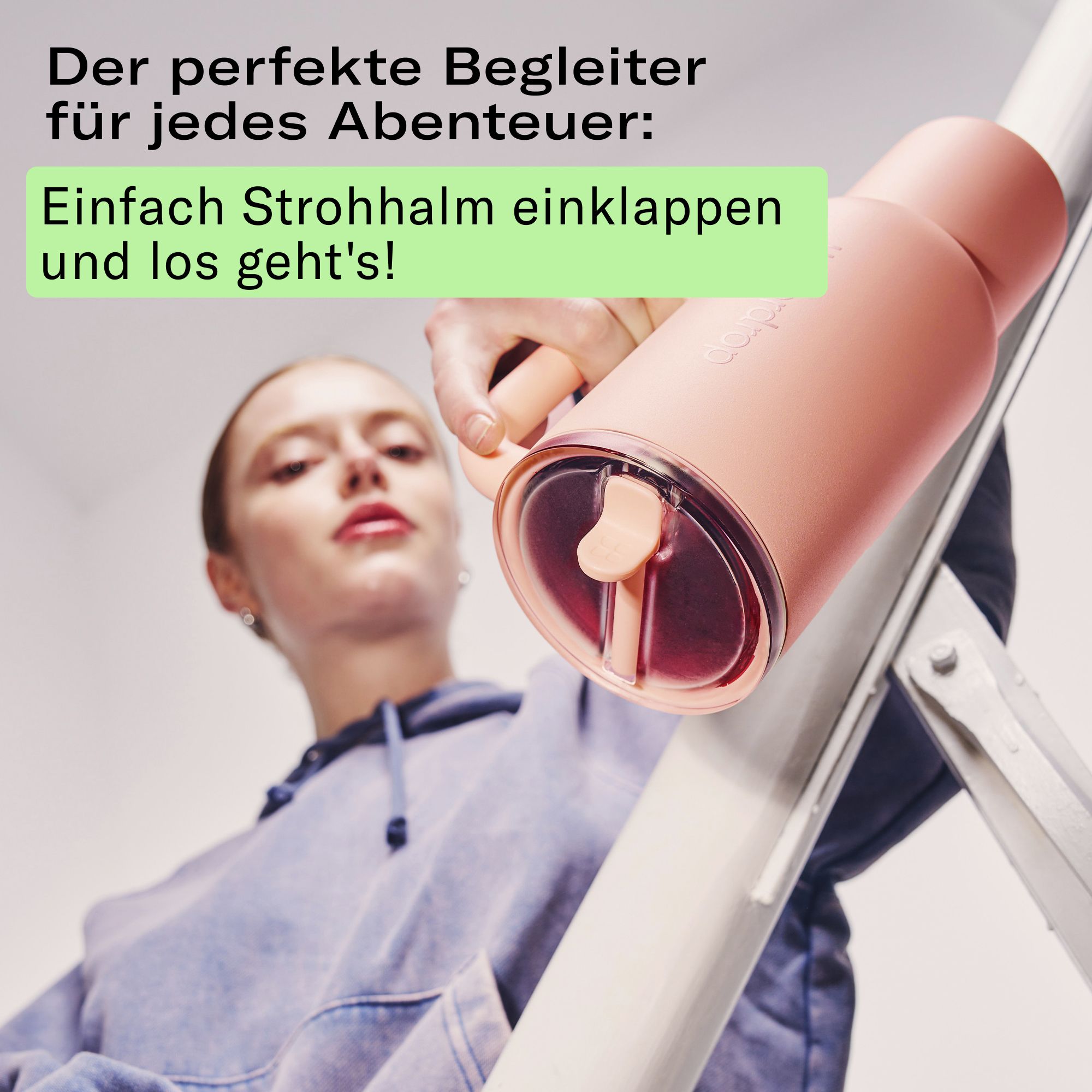 Frau klappt den Strohhalm eines Soft Pink Thermobechers XL ein.
