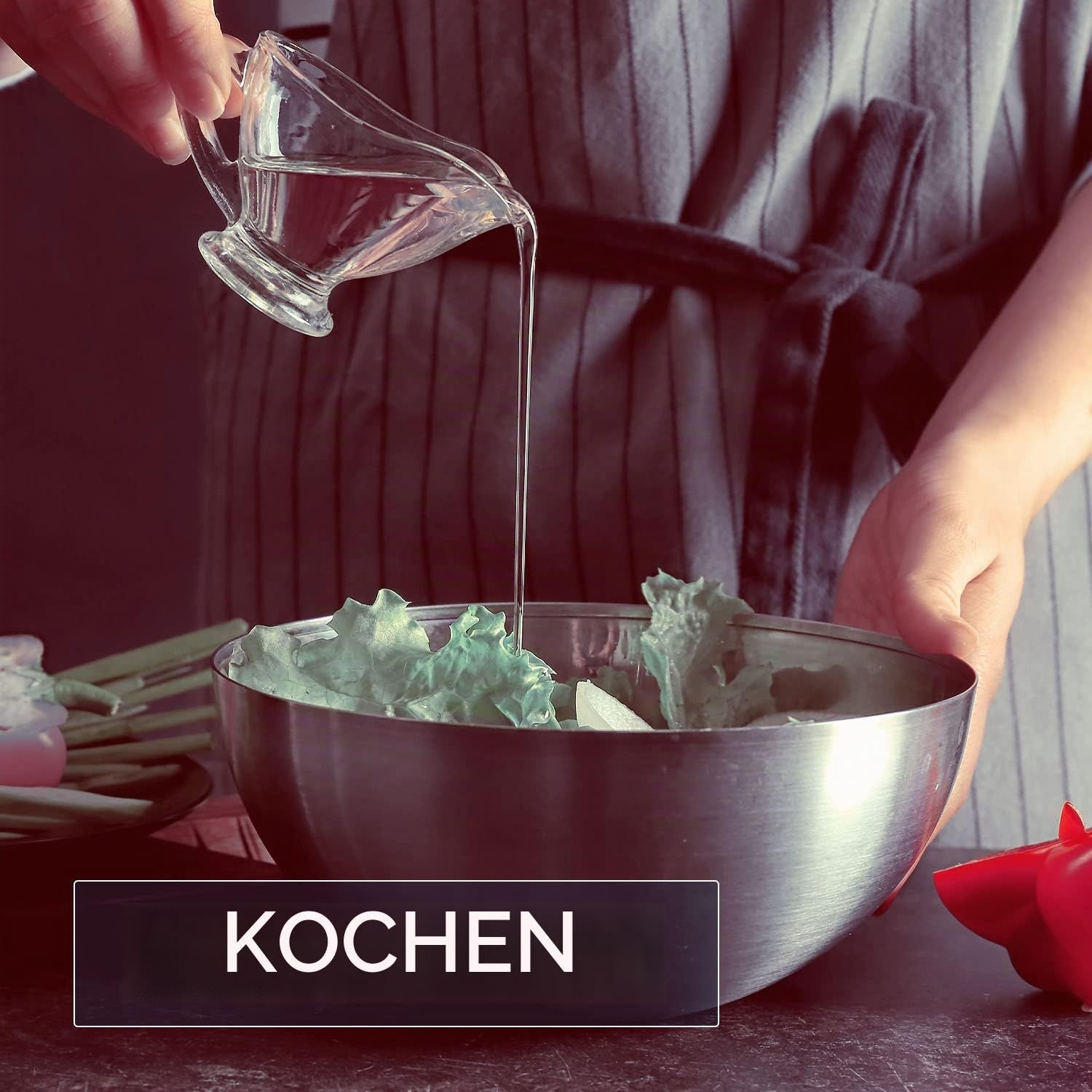 Eine Person gießt klares Öl über Salat in einer Edelstahlschüssel. Text: Kochen.