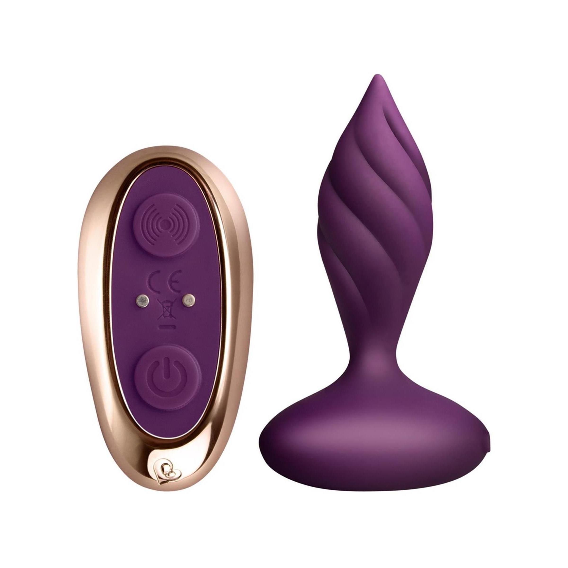 Lila Vibrator mit spiralförmiger Textur und Fernbedienung. Fernbedienung mit goldfarbenem Rahmen und Bedienelementen.