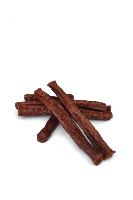 Mehrere braune, längliche Kaustangen für Hunde liegen auf weißem Grund. Die Stangen sind unregelmäßig geformt.