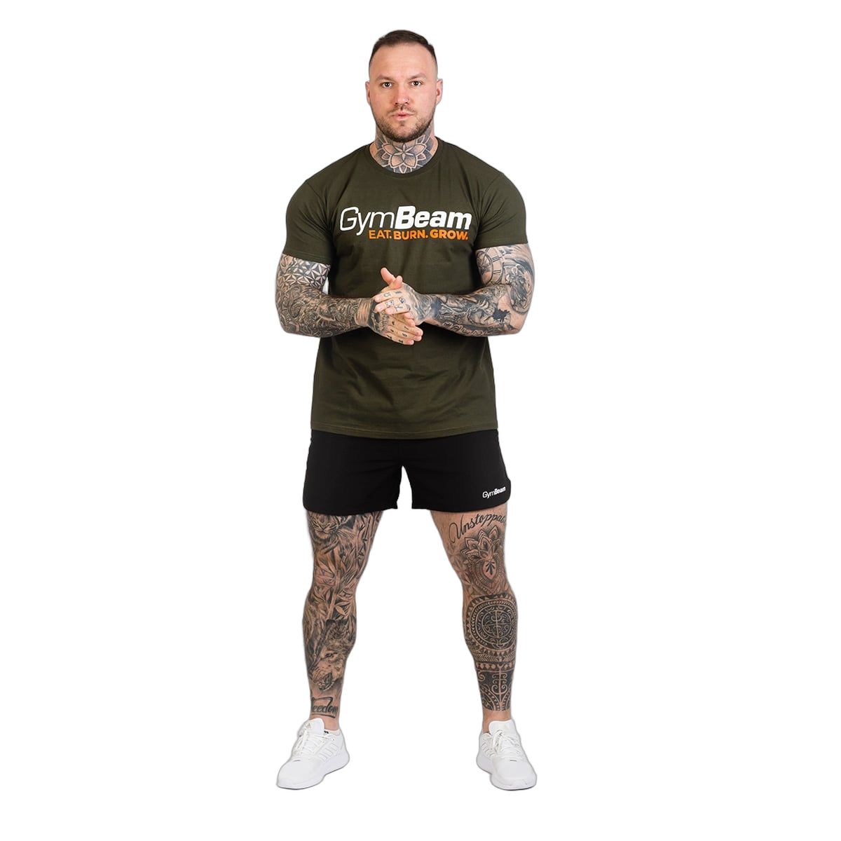 Mann in Militärgrünem GymBeam T-Shirt und schwarzen Shorts, Ganzkörperansicht.