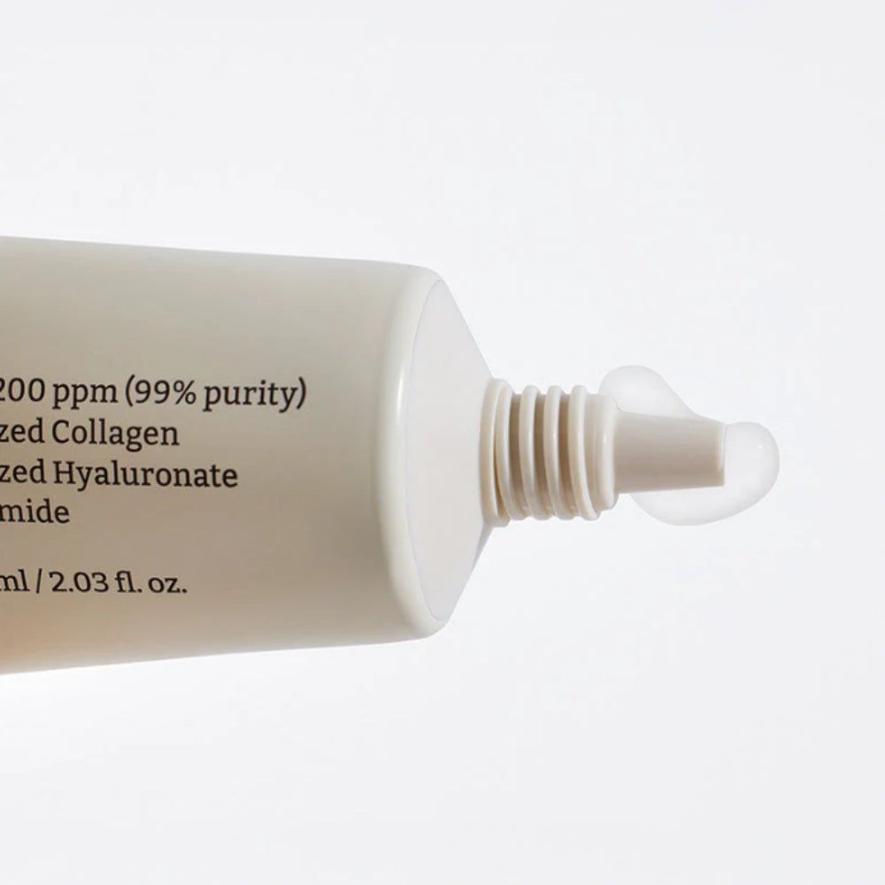 Nahaufnahme der Spitze einer geöffneten Tube Dr. Reju-All Advanced PDRN Rejuvenating Cream, mit einem Tropfen Creme.