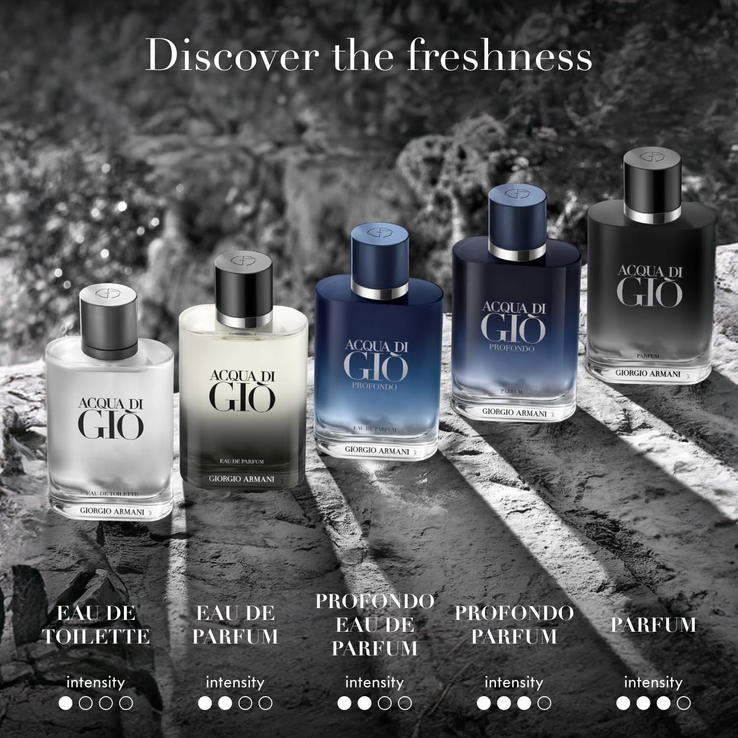 Fünf Giorgio Armani Acqua di Gio Parfümflaschen in verschiedenen Größen und Farben, auf Felsen arrangiert.
