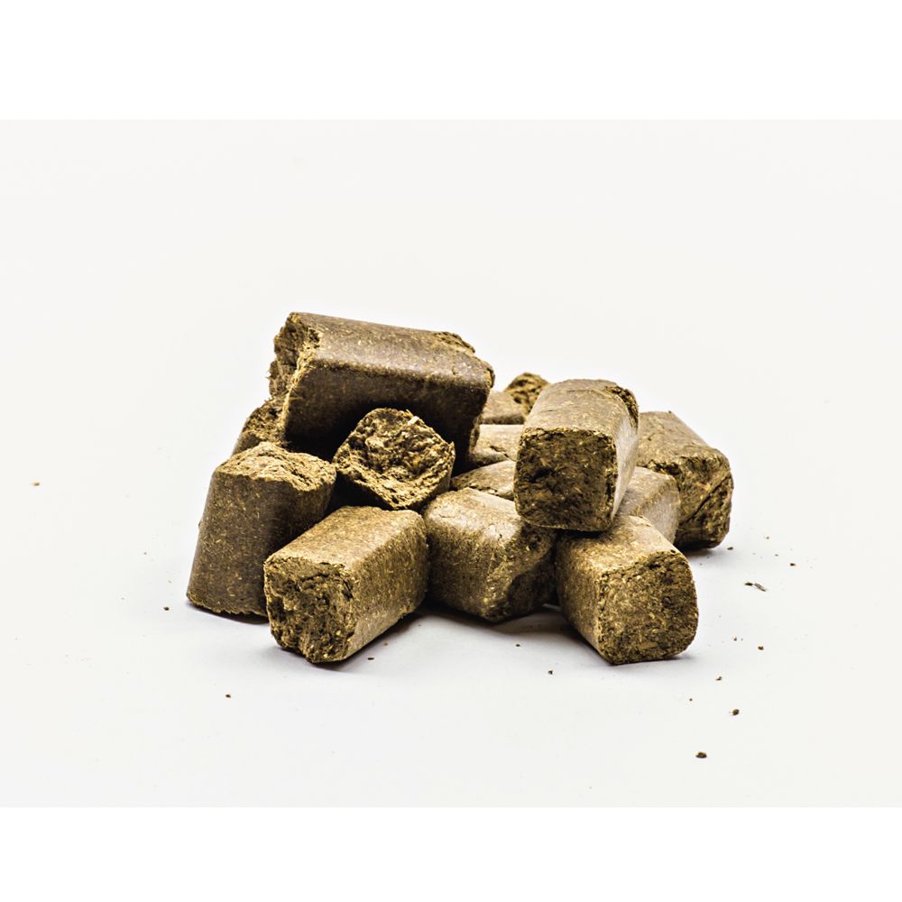 Haufen brauner, quaderförmiger Leckerlis auf weißem Hintergrund.
