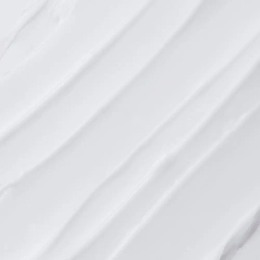 Nahaufnahme von weißer Creme. Strukturierte Oberfläche mit diagonalen Linien.
