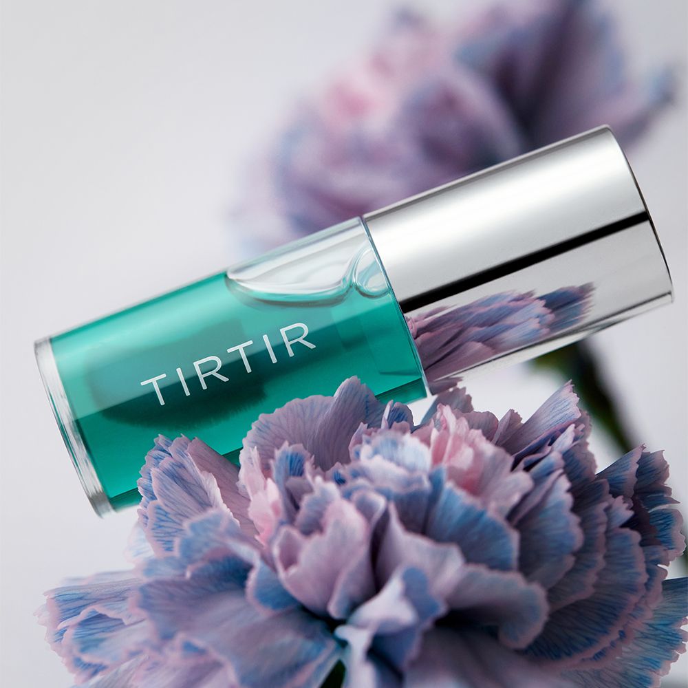 Lip Oil in einer transparenten Flasche mit silbernem Deckel. Der Inhalt ist grün. Auf der Flasche steht "TIRTIR".