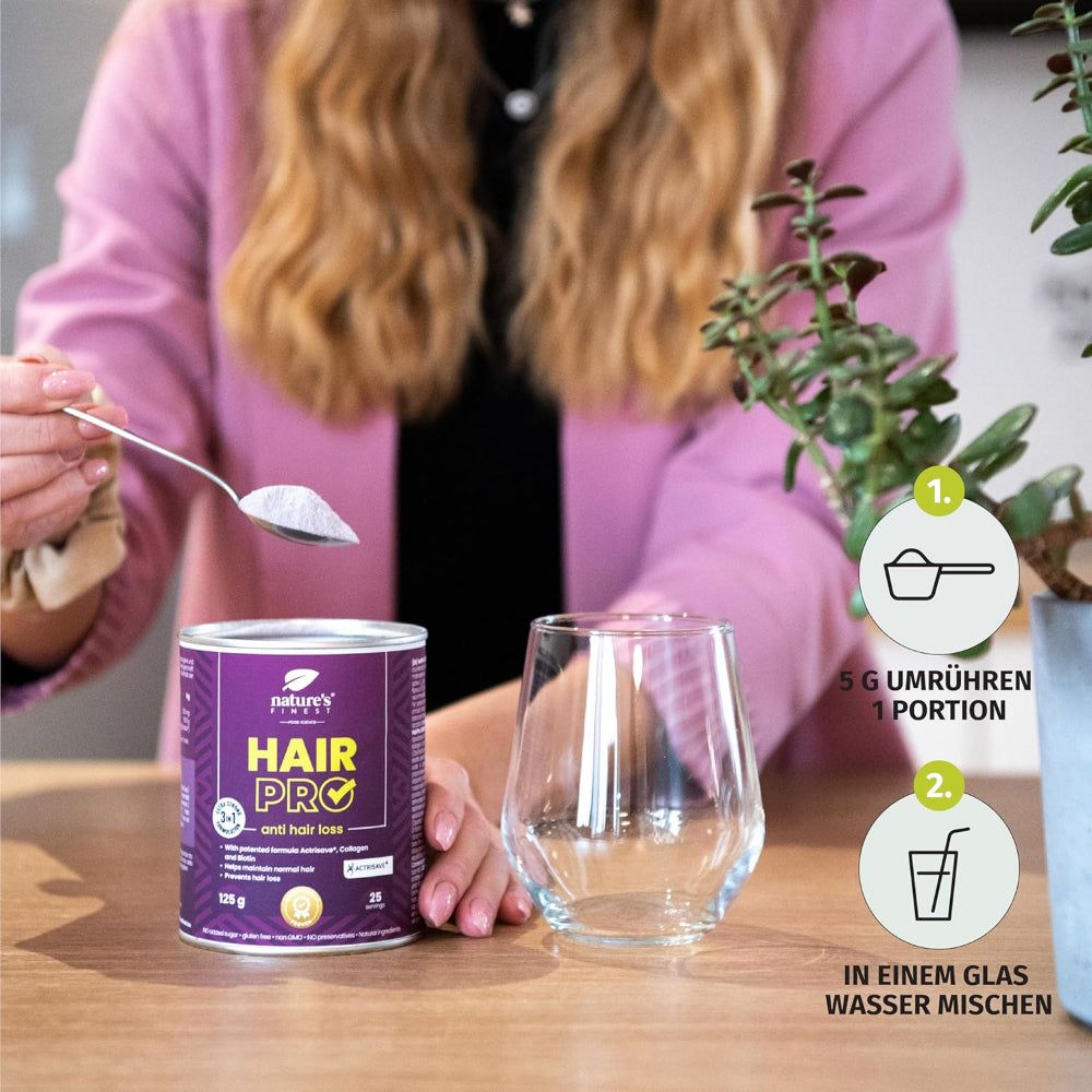 Person hält Löffel mit Pulver über Glas. Dose und Anweisungen im Hintergrund. Text: 5 g umrühren, in Glas mischen.