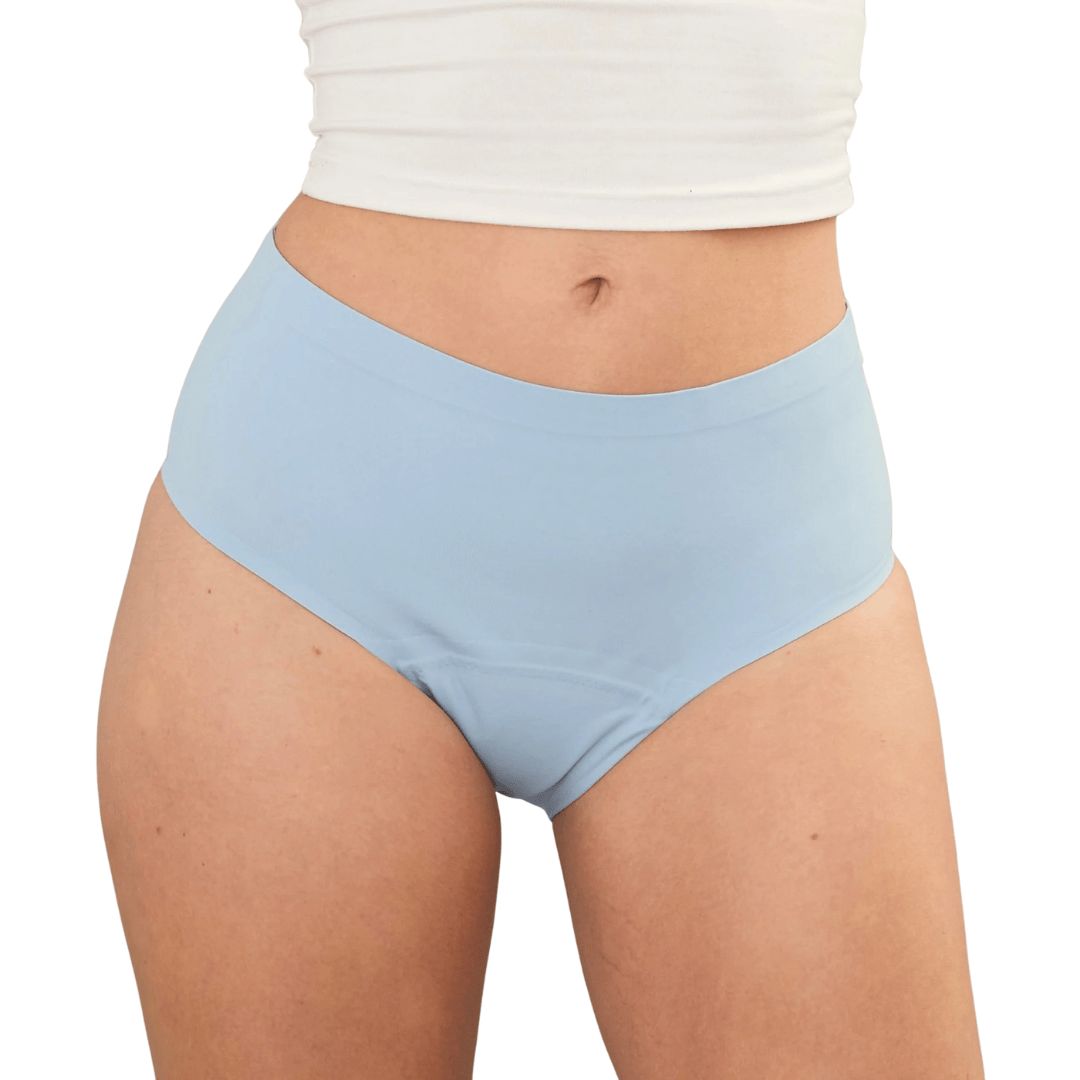 Hellblaue, nahtlose, auslaufsichere Unterhose. Hoher Bund, bedeckt den Bauch. Trägerin trägt ein weißes Top.