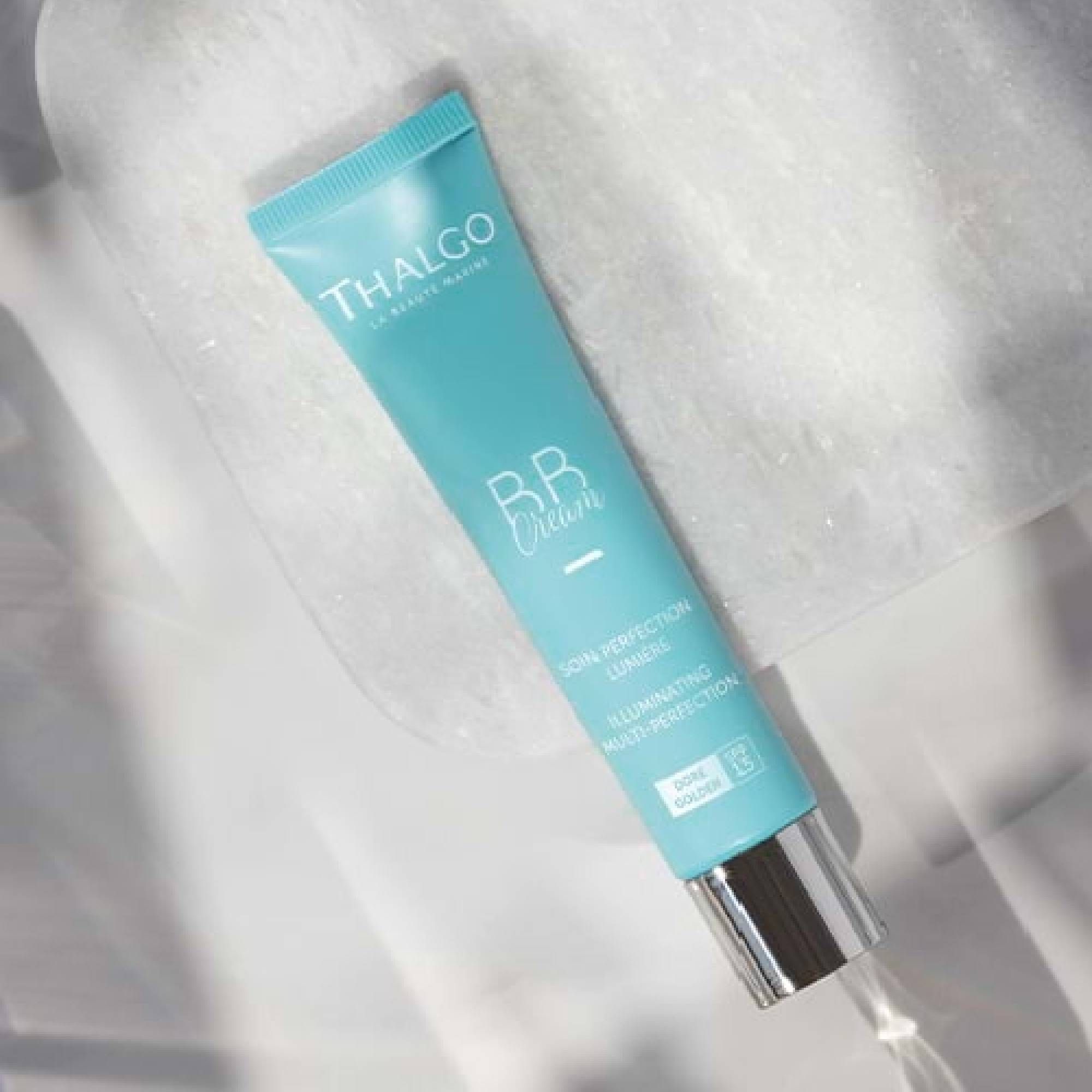 Türkisfarbene Tube mit THALGO BB Cream Aufschrift. Silberner Verschluss. Text: SOIN PERFECTION LUMIERE, ILLUMINATING MULTI-PERFECTION, DORÉ, SPF 15.