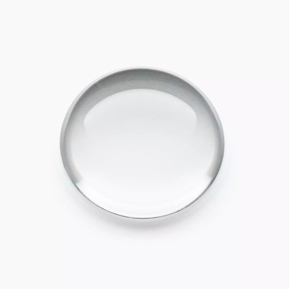 Runde, transparente Glasplatte, vermutlich ein Objektiv oder eine Lupe.