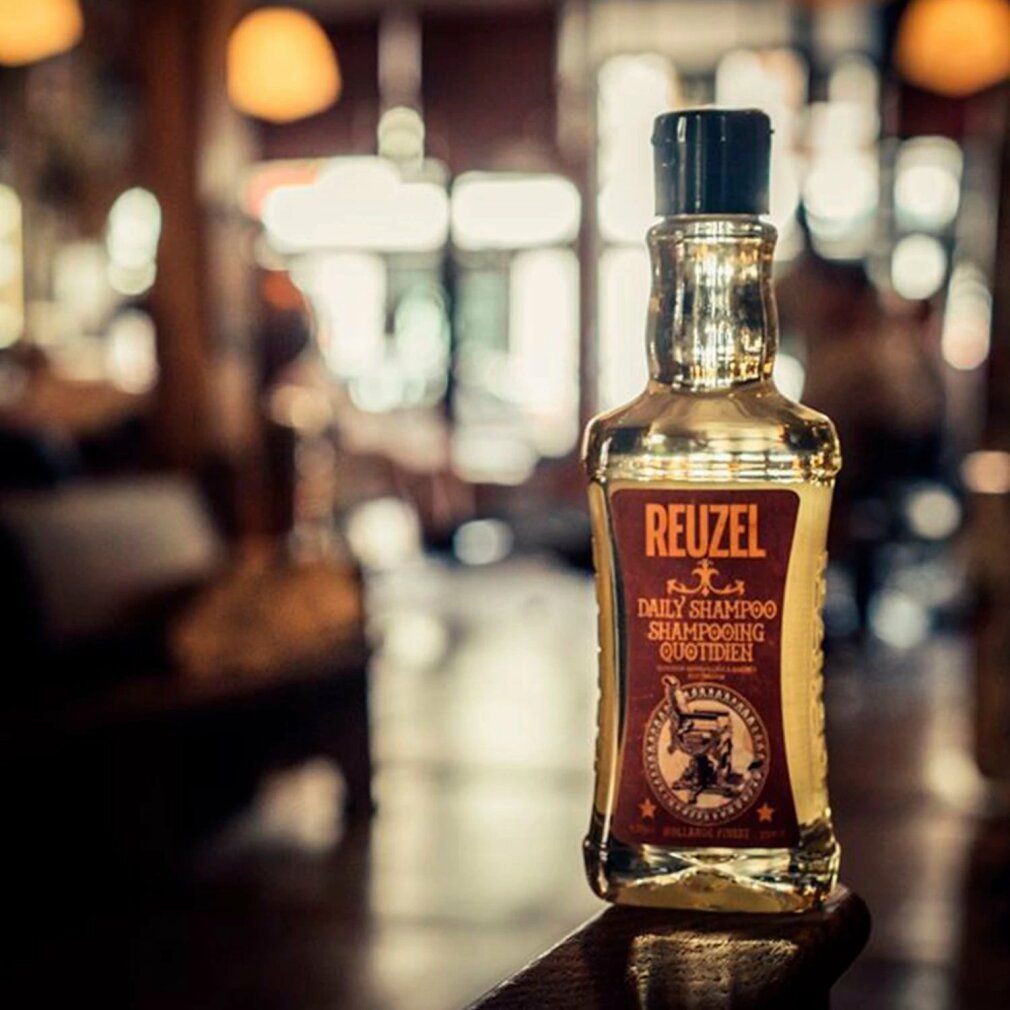Reuzel Daily Shampoo Flasche in einem Friseursalon-Ambiente.