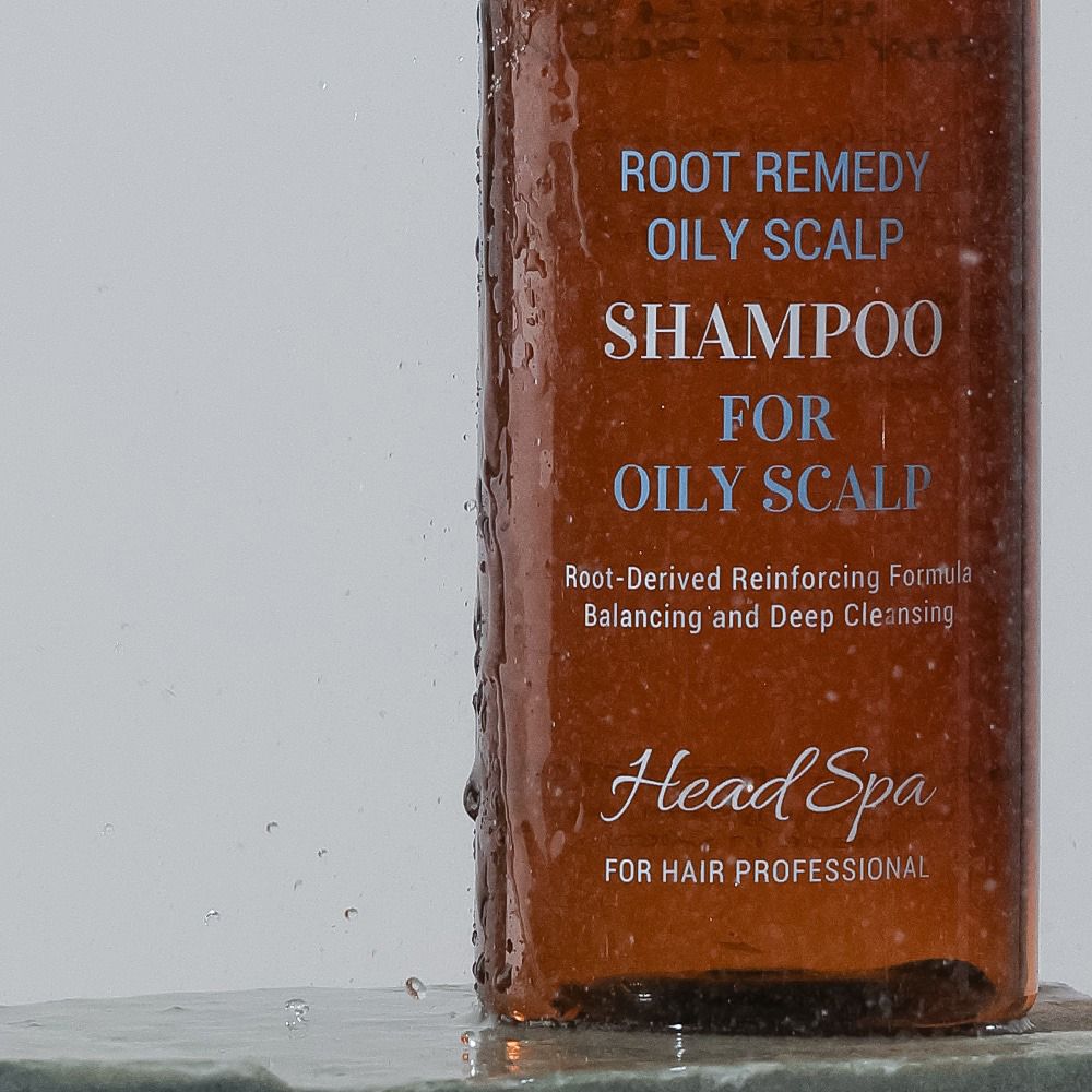Nahaufnahme der Shampoo-Flasche. Text: Root Remedy Oily Scalp Shampoo for Oily Scalp, Head Spa.