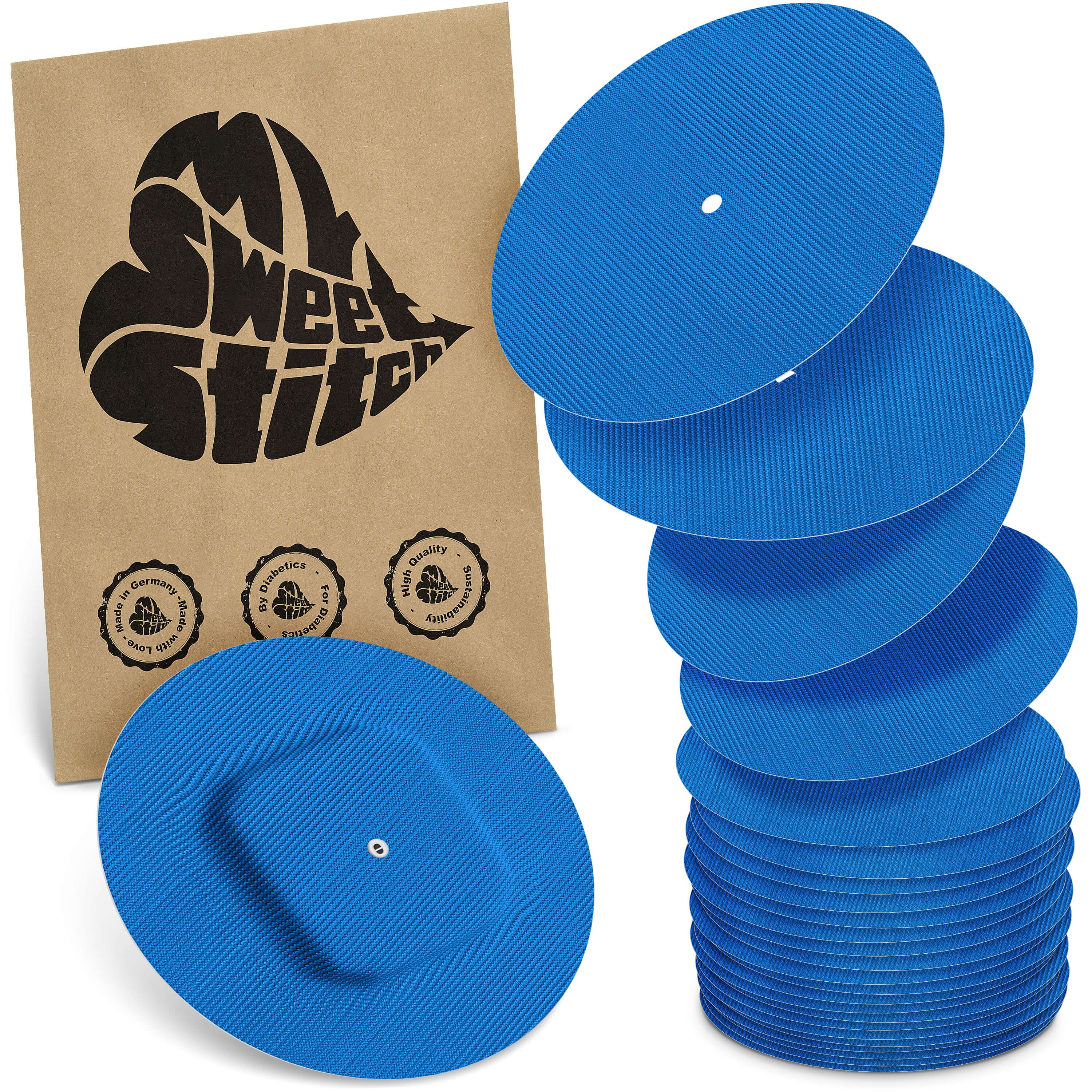 Blaue, runde Pflaster mit geriffelter Oberfläche. Neben einer braunen Verpackung mit Logo und Qualitätssiegeln gestapelt.