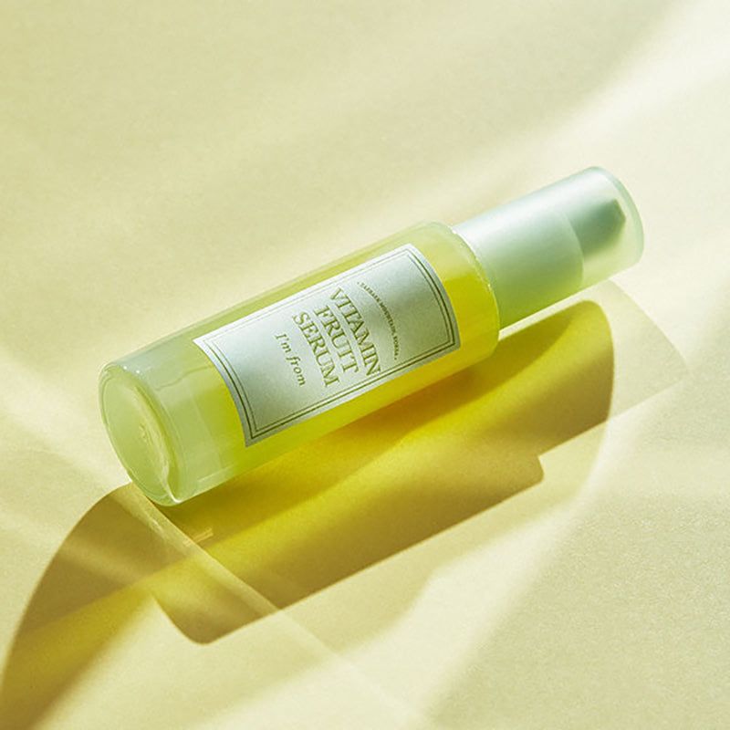 Serumflasche mit Etikett. Aufschrift: Vitamin Fruit Serum, I'm from. Flasche liegt schräg.