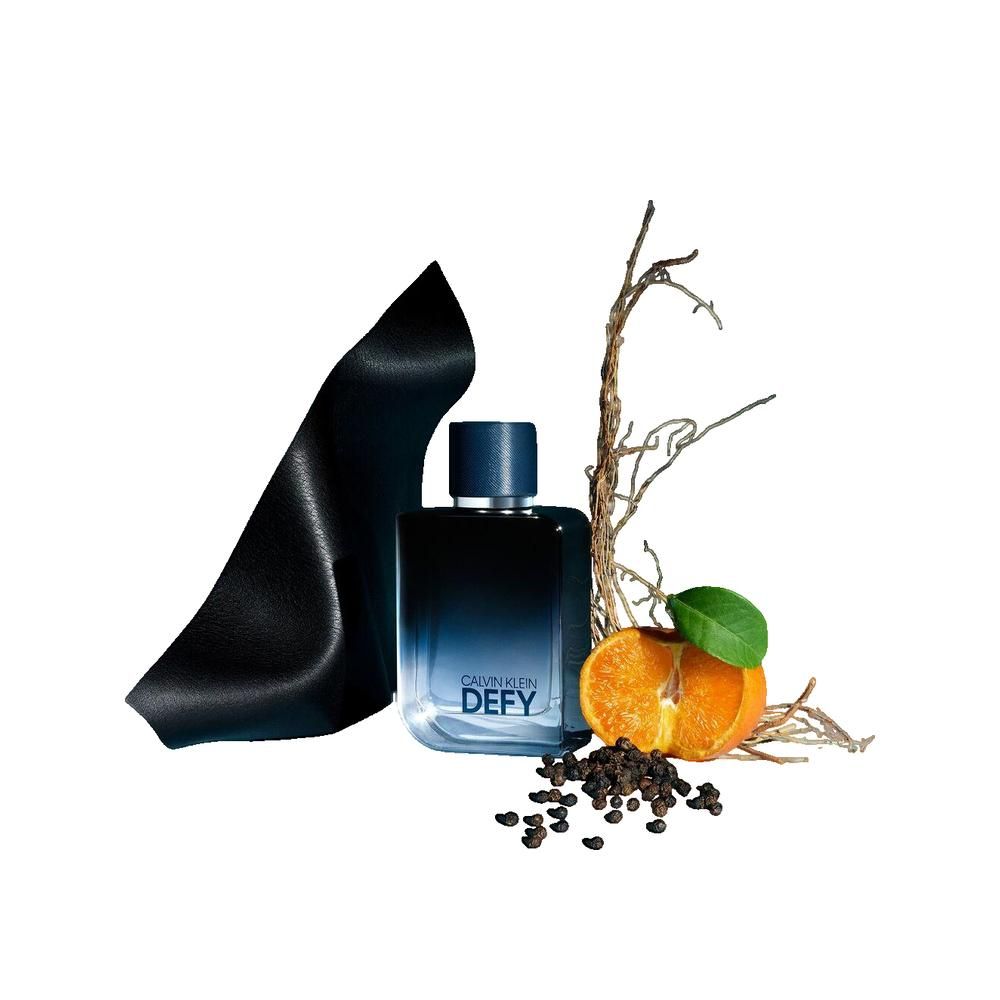 Dunkelblaues Parfümflakon mit Aufschrift DEF. Neben Früchten, Zweigen und schwarzem Band. Flakon mit blauem Deckel.