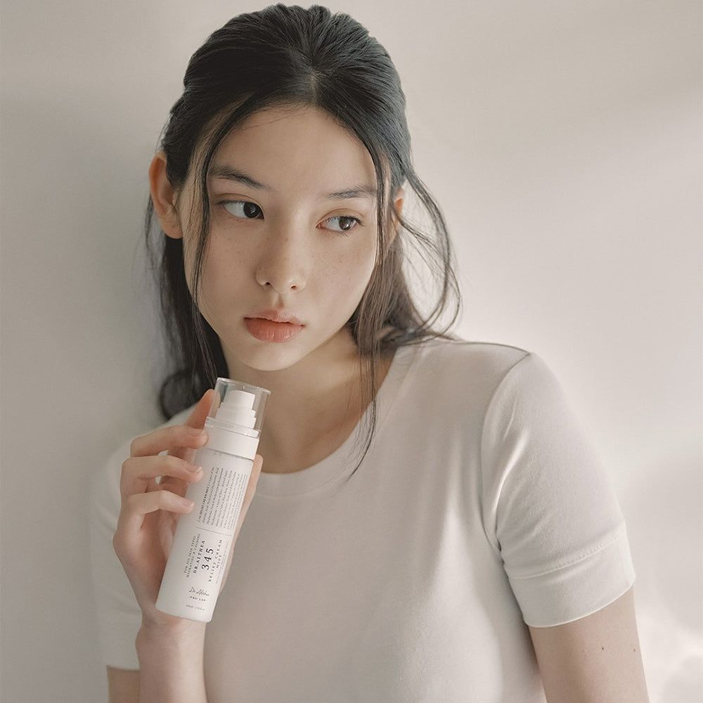 Junge Frau hält eine weiße Sprühflasche. Aufschrift: 345 Relief Cream Mist, Dr. Althea. Sie blickt zur Seite.