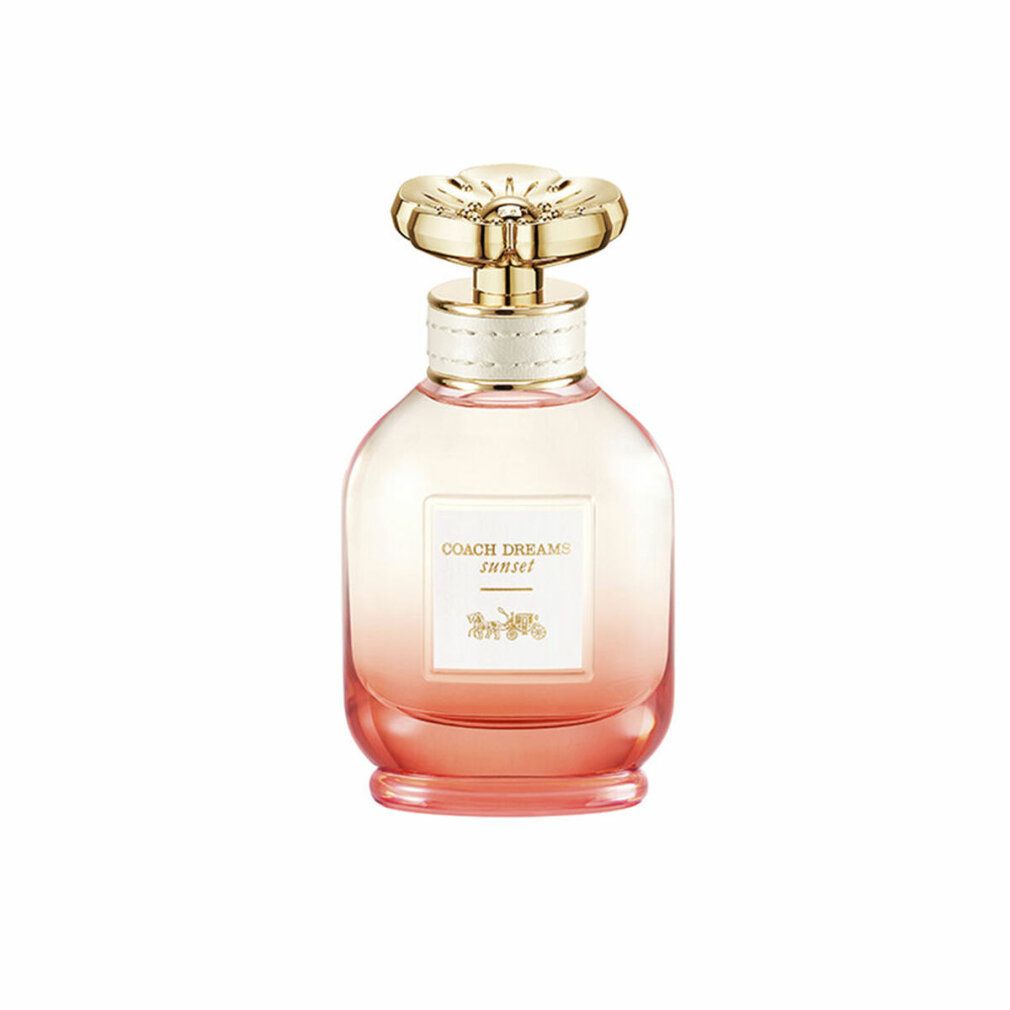 Parfümflakon mit goldfarbenem Deckel. Aufkleber mit "COACH DREAMS sunset". Farbverlauf von rosa nach orange. Floral geformter Deckel.