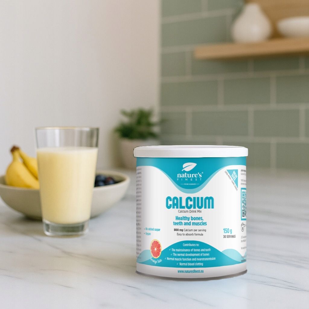 Nature's Finest Calcium Dose mit Glas und Früchten auf einer Küchenarbeitsplatte.