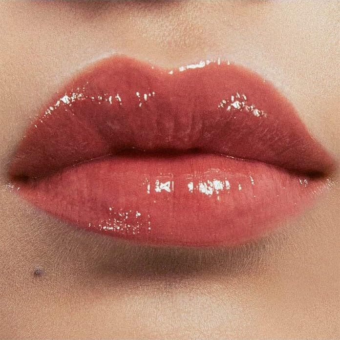 Nahaufnahme von glänzenden, rosafarbenen Lippen. Die Lippen sind leicht geöffnet.