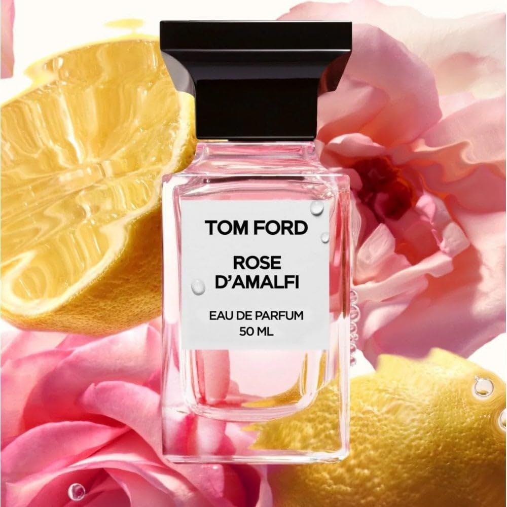 Parfümflakon mit weißem Etikett. Aufschrift: TOM FORD, ROSE D'AMALFI, Eau de Parfum, 50 ML. Flakon vor Rosen und Zitronen.