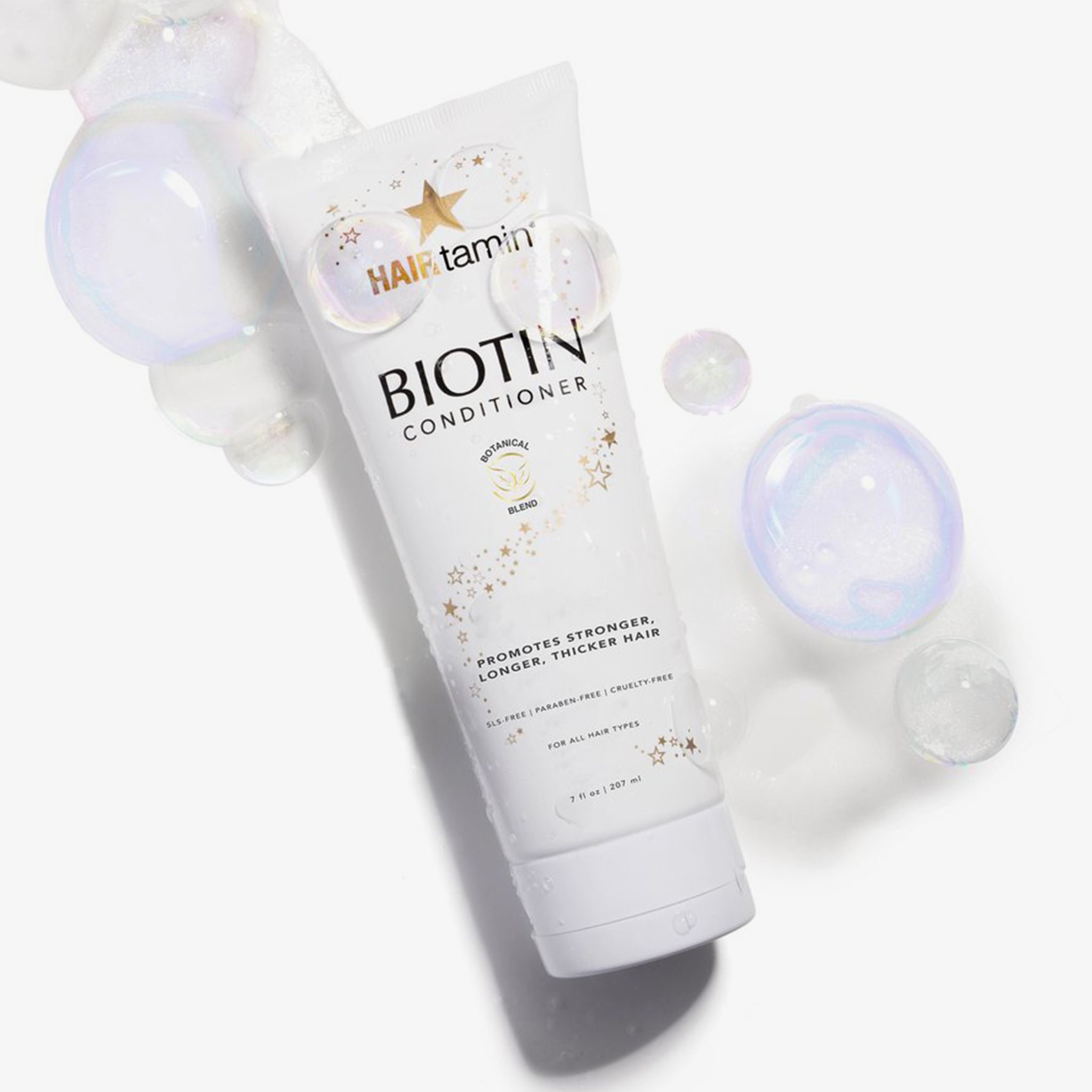 Weiße Tube "HAIRtamin Biotin Conditioner" mit Seifenblasen. "Botanical Blend". Für alle Haartypen. 207 ml.
