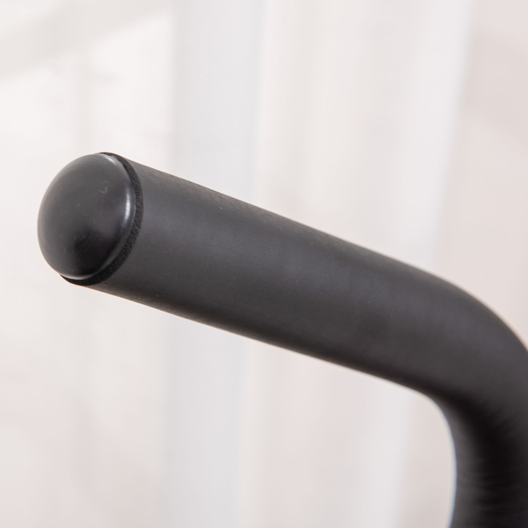 Nahaufnahme des schwarzen Griffs eines Steppers. Runde Form, glatte Oberfläche.