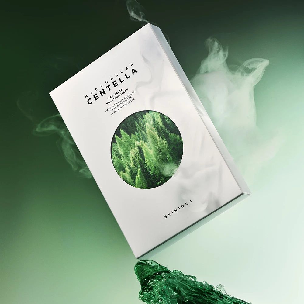 Box mit Produktnamen und Waldmotiv, umgeben von Dampf und grüner Flüssigkeit. Text: Madagascar Centella, Tea-Trica Relaxing Mask, SKIN1004.