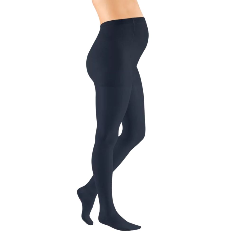 Dunkelblaue Kompressions-Umstandshose. Seitliche Ansicht einer Person, die die Hose trägt. Blick auf den Bauch und die Beine.