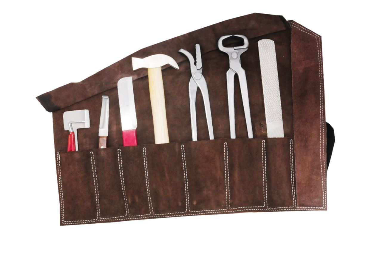 Werkzeug-Set in brauner Ledertasche. Enthält Hufmesser, Hammer, Zangen und Raspel. Werkzeuge in separaten Fächern.