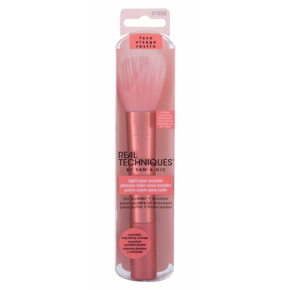 Puderpinsel in Verpackung. Rosa Borsten, kupferfarbener Griff. "REAL TECHNIQUES" und "Light Layer Powder" sichtbar.