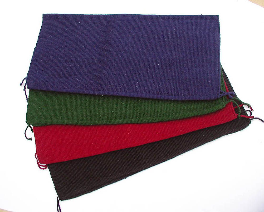 Mehrere farbige Satteldecken, übereinander gelegt. Farben: Blau, Grün, Rot und Braun. Mit Kordel an den Ecken.
