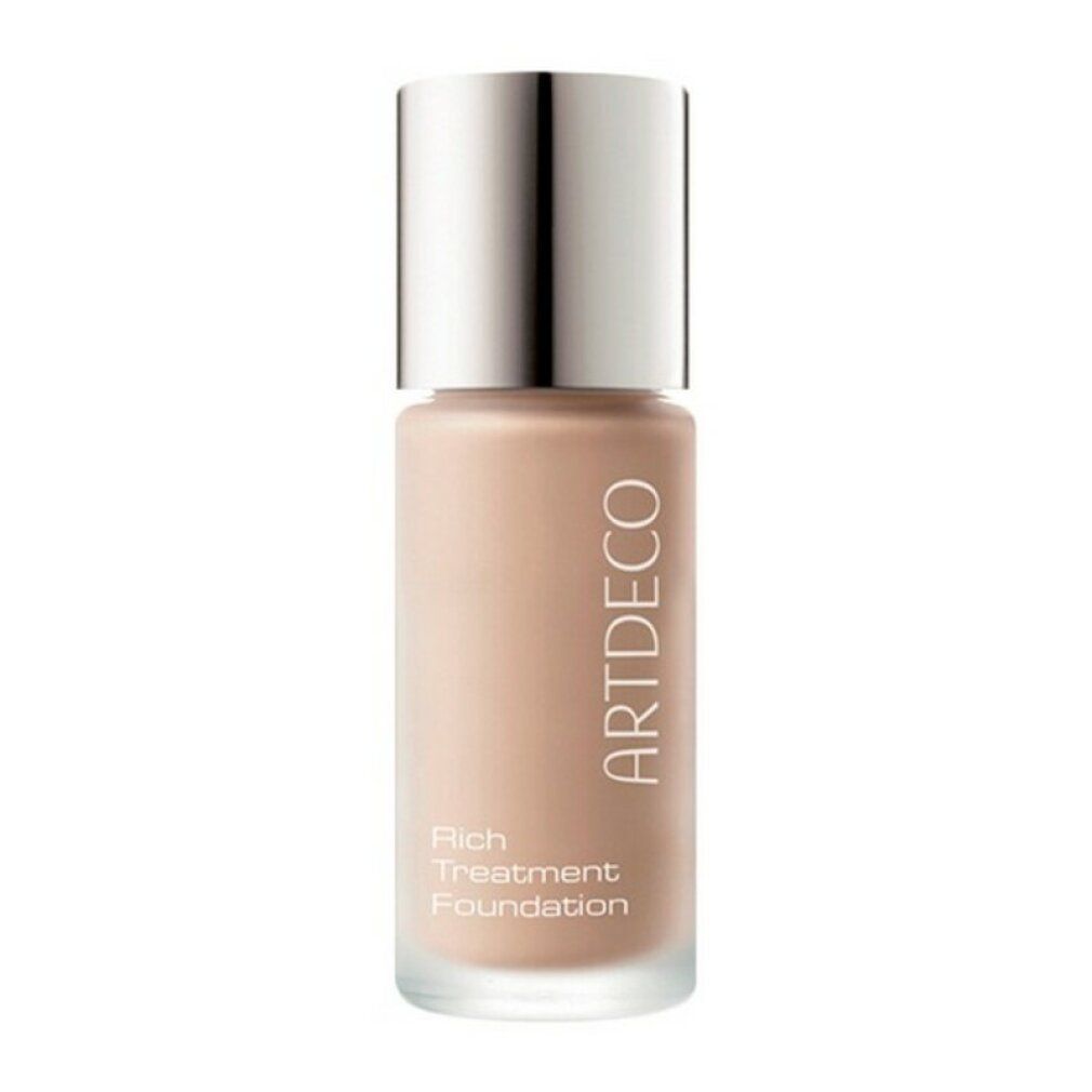 Artdeco Rich Treatment Foundation Flasche. Beige Flüssigkeit, silberner Deckel. Produktname sichtbar.