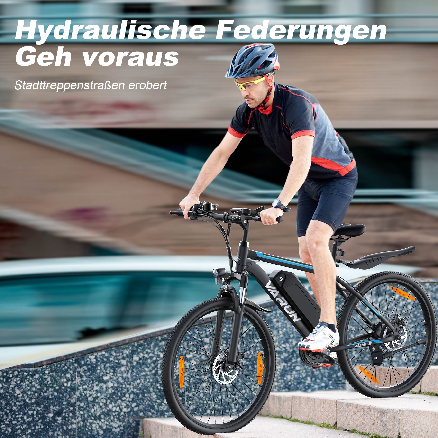 Mann fährt ein VARUN Elektro-Mountainbike eine Treppe hinauf. Blaue und schwarze Farbgebung. Helm und Sportkleidung.