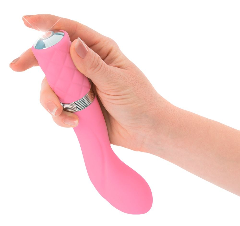 Rosa Vibrator, in einer Hand gehalten. Griff mit Rautenmuster. Silberfarbener Ring.