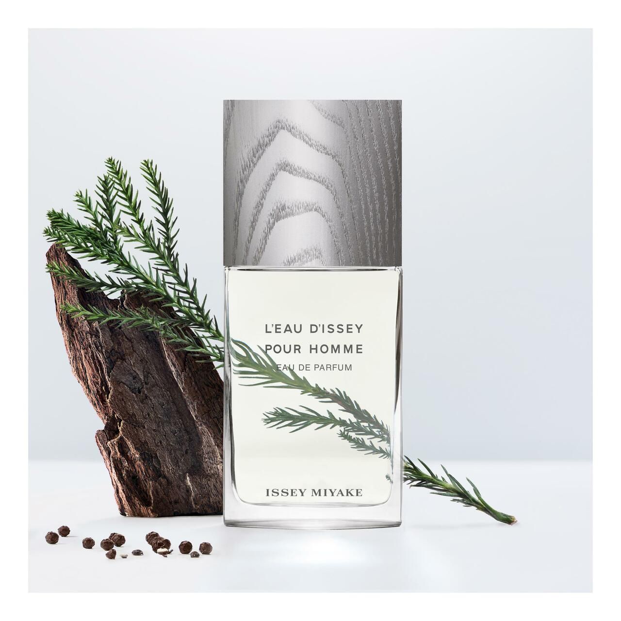 Flakon mit Holzdeckel, umgeben von Zweigen, Rinde und Pfefferkörnern. Aufschrift: L'EAU D'ISSEY POUR HOMME, Eau de Parfum, ISSEY MIYAKE.