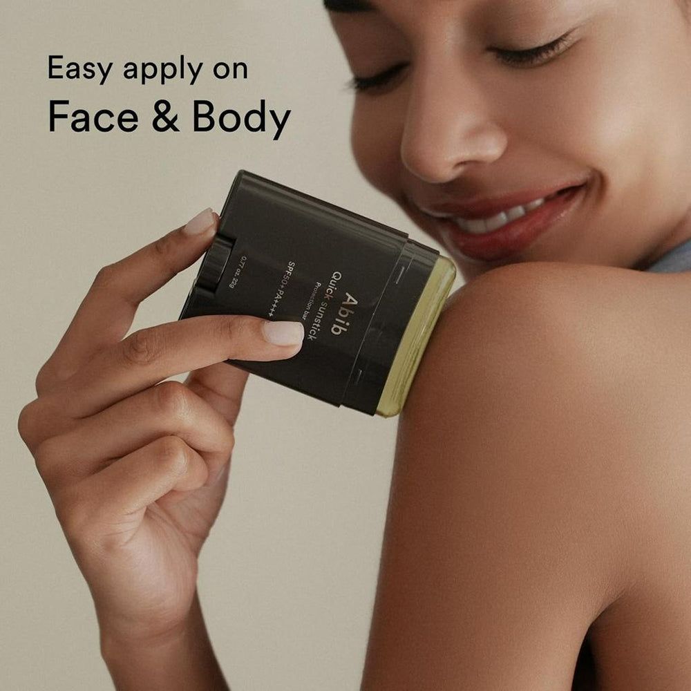 Eine Person trägt einen schwarzen ABIB Quick Sunstick Protection Bar auf die Schulter auf. Text: Easy apply on Face & Body.