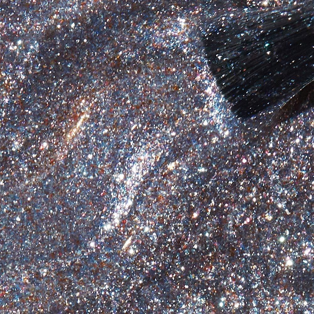 Nahaufnahme von glitzerndem Nagellack. Ein Pinsel berührt die Oberfläche. Der Lack hat eine silberne Farbe mit Glitzerpartikeln.
