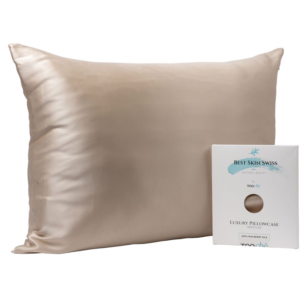Beiges Seidenkissen und Verpackung. Verpackung mit Aufschrift "BEST SKIN SWISS" und "LUXURY PILLOWCASE".