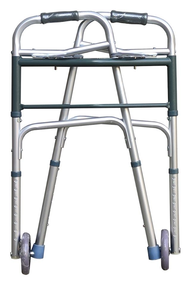Gefaltete Gehhilfe aus Aluminium. Silberfarbenes Gestell, graue Räder und Handgriffe. Kompakte Form.